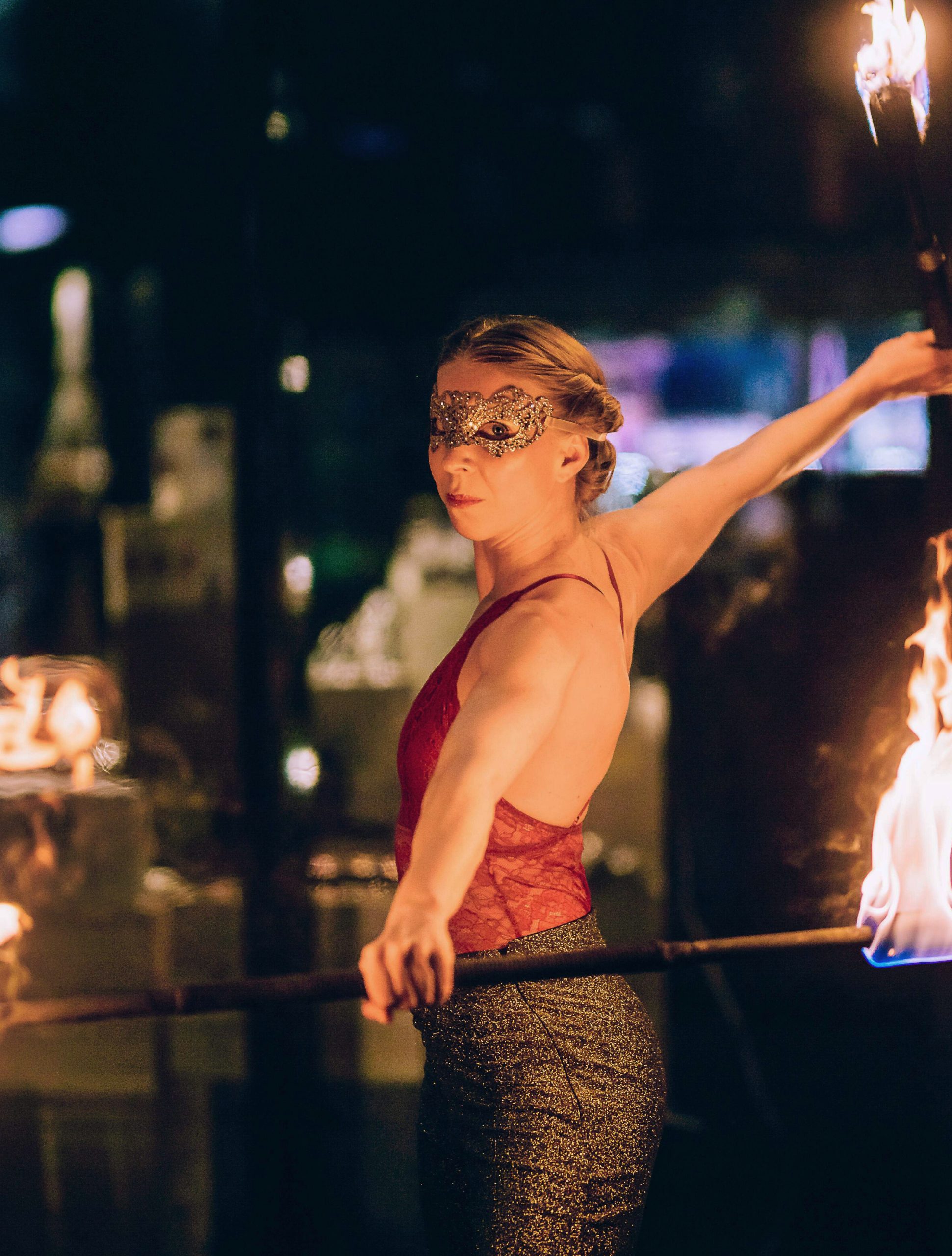 Kvinna med mask som håller i en brinnande stav