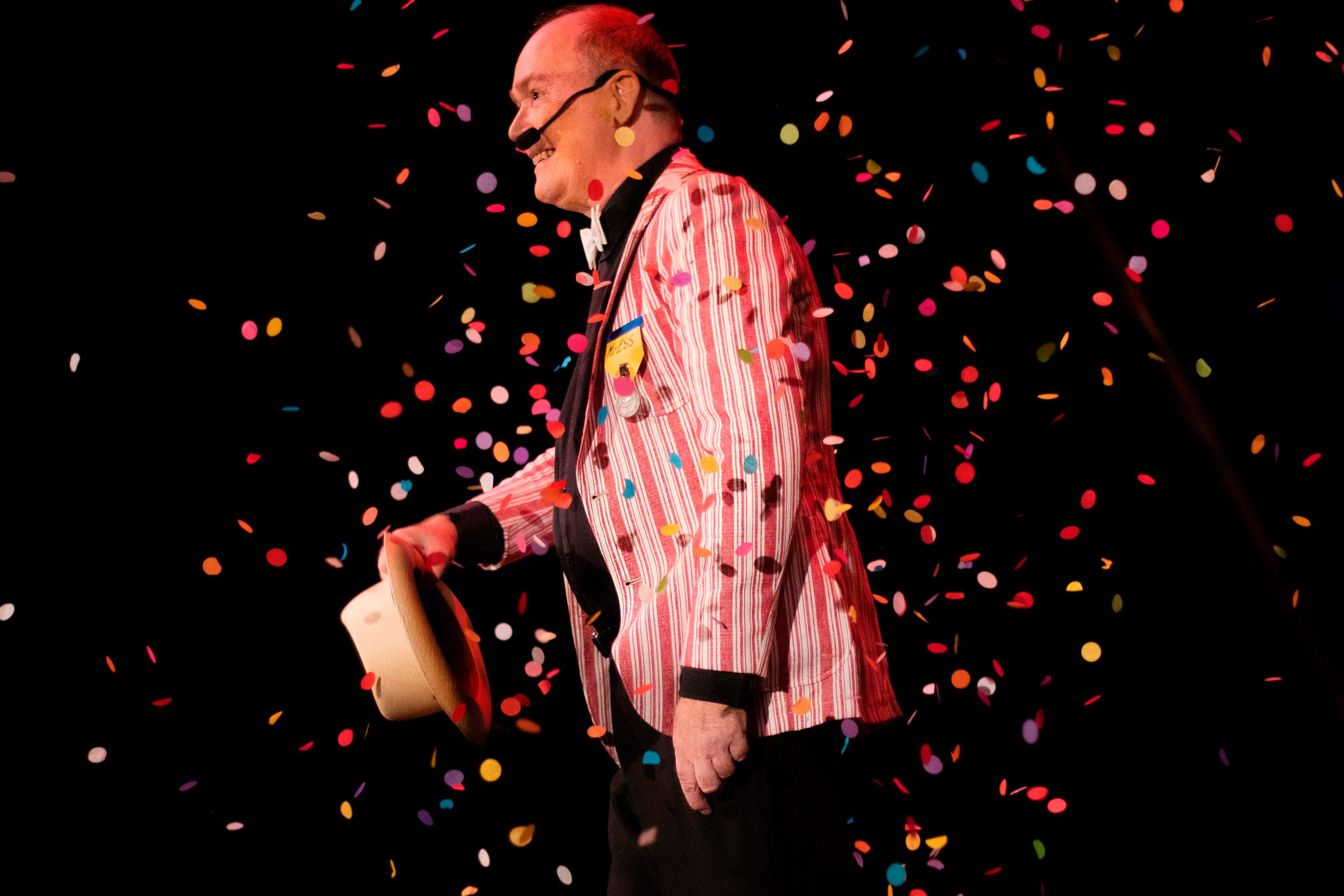 Manlig cirkusartist står i konfettiregn
