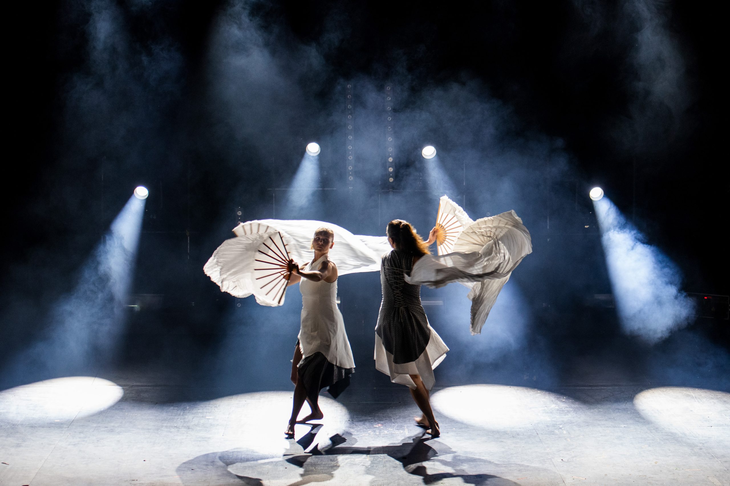 Två dansare med vita skynken på scen